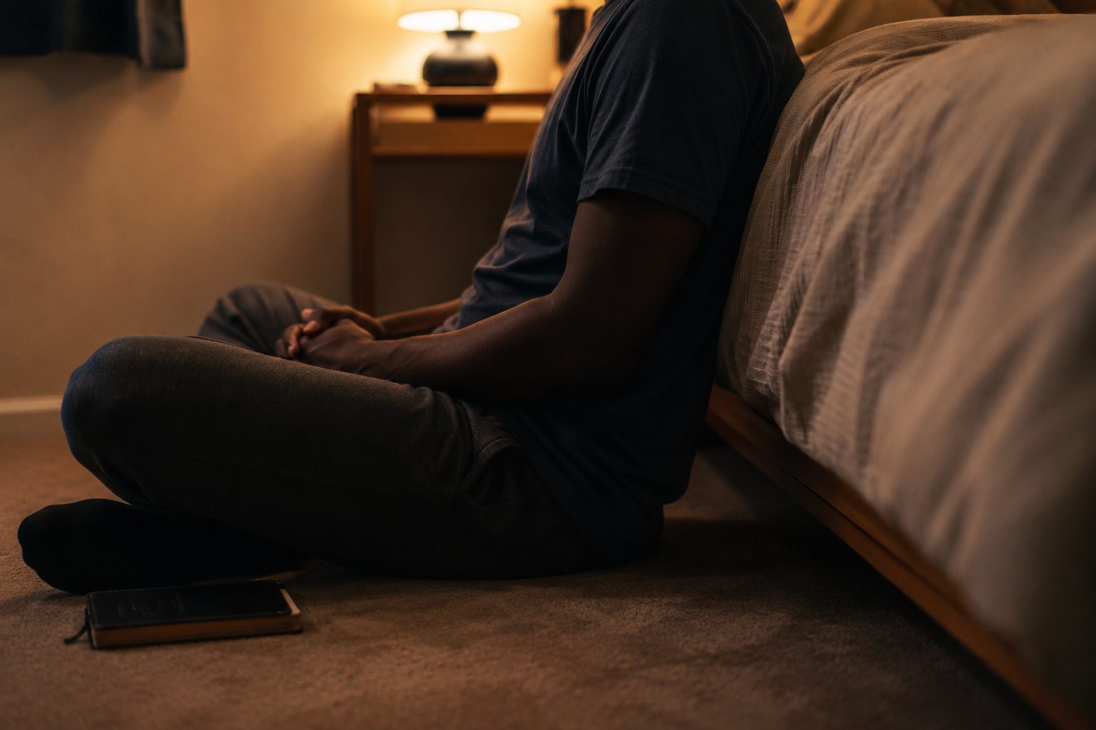 a person seated quietly in prayer at home in the evening, the right posture before God in financial matters